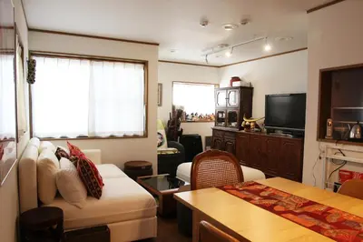 a living room with a couch and a tv at HAMA HILLS Shinjuku in Tokyo