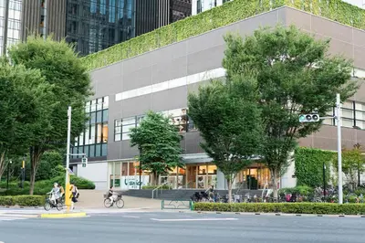 a building with people riding bikes in front of it at HAMA HILLS Shinjuku in Tokyo