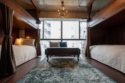 a bedroom with two beds and a chandelier at Creare Ryogoku in Tokyo