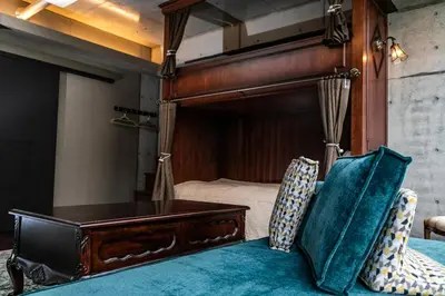 a bedroom with a canopy bed with a desk and chairs at Creare Ryogoku in Tokyo