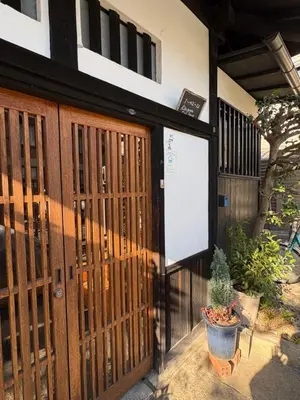 a building with a wooden door with a sign on it at Kitazawa Cozy House in Tokyo