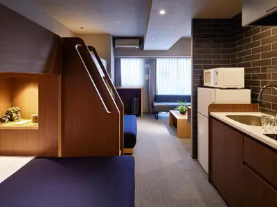 a kitchen with a sink and a couch in a room at Minn Ueno in Tokyo
