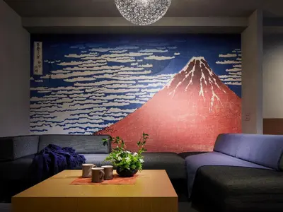 a living room with a couch and a mountain mural at Minn Ueno in Tokyo