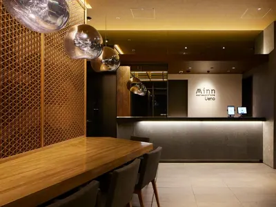 a dining room with a wooden table and chairs at Minn Ueno in Tokyo