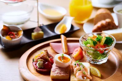 a plate of food with eggs and bread on a table at The Gate Hotel Ryogoku by Hulic in Tokyo