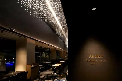 a dining room with tables and stools and lights at The Gate Hotel Ryogoku by Hulic in Tokyo