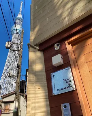 a sign on the door of a building with a tower in the background at Touch and Go Azumabashi - Vacation STAY 85085 in Tokyo