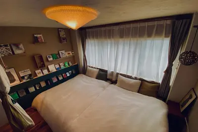 a bedroom with a large bed in front of a window at TOE LIBRARY Tokyo Asakusa in Tokyo