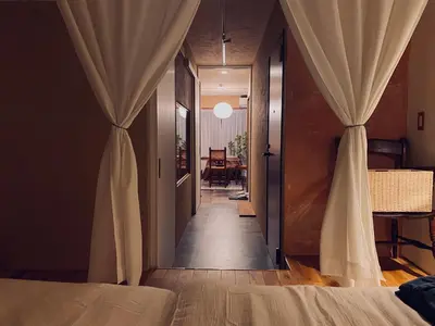 a bedroom with a bed and a hallway with curtains at TOE LIBRARY Tokyo Asakusa in Tokyo