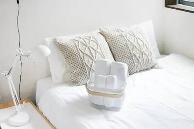 a white couch with pillows and a table with a lamp at \u30a2\u30ea\u30a2\u66f3\u821f in Tokyo