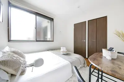 a bedroom with a bed and a table and a window at \u30a2\u30ea\u30a2\u66f3\u821f in Tokyo