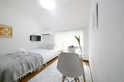 a white bedroom with a bed and a desk at \u30a2\u30ea\u30a2\u66f3\u821f in Tokyo
