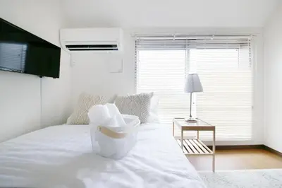 a white bed in a room with a window at \u30a2\u30ea\u30a2\u66f3\u821f in Tokyo