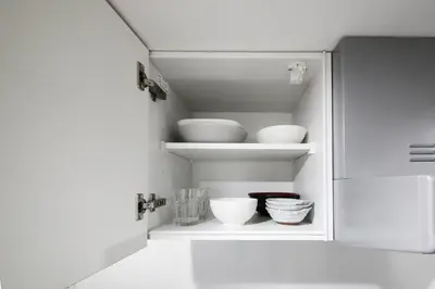 a white cabinet with bowls and other dishes in it at \u30a2\u30ea\u30a2\u66f3\u821f in Tokyo