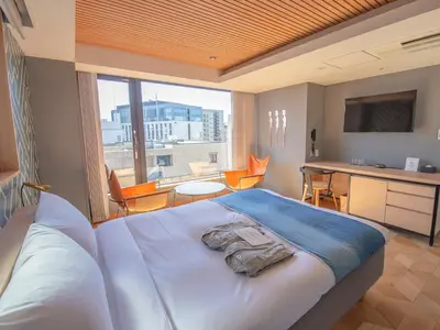 a bedroom with a bed and a desk and a window at Asakusa Kokono Club Hotel in Tokyo
