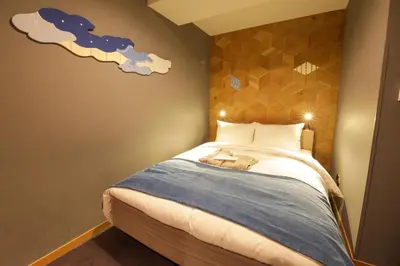 a bedroom with a bed with clouds painted on the wall at Asakusa Kokono Club Hotel in Tokyo