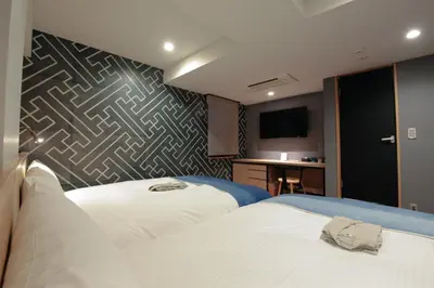 a hotel room with two beds and a desk at Asakusa Kokono Club Hotel in Tokyo