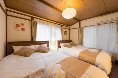 a bedroom with two beds and a chandelier at Yoshinaga heights in Tokyo