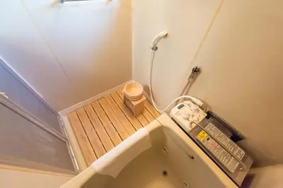a small bathroom with a bath tub with a wooden floor at Yoshinaga heights in Tokyo