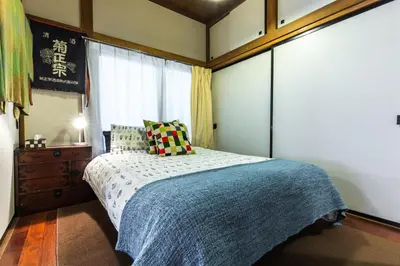 a bedroom with a bed and a dresser and a window at Samurai House - Large Family House, West Shinjuku in Tokyo
