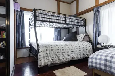a bedroom with a bunk bed with a white bedspread at Samurai House - Large Family House, West Shinjuku in Tokyo