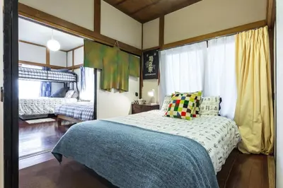 a bedroom with a bed with a blue blanket at Samurai House - Large Family House, West Shinjuku in Tokyo