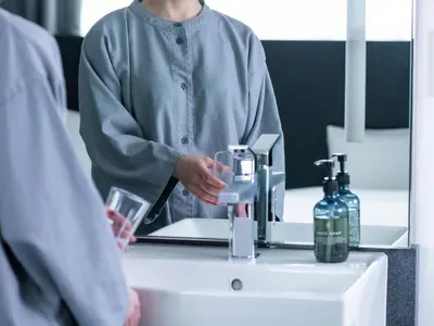a woman standing in front of a sink with a mirror at sequence SUIDOBASHI - Tokyo in Tokyo