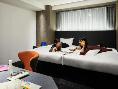 two people laying on a bed in a hotel room at sequence SUIDOBASHI - Tokyo in Tokyo
