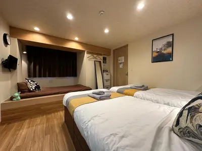 a hotel room with two beds and a window at nestay villa tokyo akihabara in Tokyo