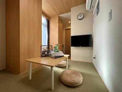 a room with a table and a clock on a wall at nestay villa tokyo akihabara in Tokyo