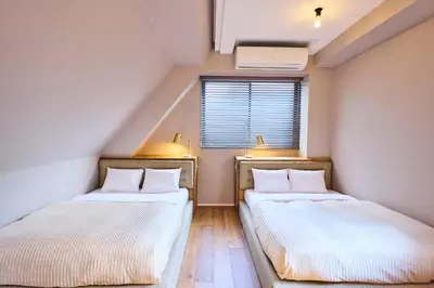 two beds in a small room with a window at Hotel Vintage Tokyo Kagurazaka in Tokyo