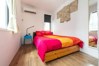 a bedroom with a bed with a colorful blanket at Pencil House - 10 mins walk to Shinjuku in Tokyo