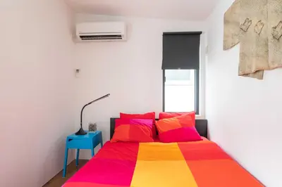 a bedroom with a bed with a colorful blanket at Pencil House - 10 mins walk to Shinjuku in Tokyo