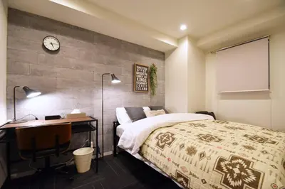 a bedroom with a bed and a desk and a clock at REGALO Shibaura - Vacation STAY 87447 in Tokyo