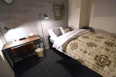 a bedroom with a bed and a desk with a lamp at REGALO Shibaura - Vacation STAY 87447 in Tokyo