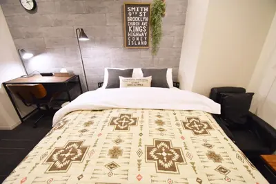 a bed in a room with a table and a bedspread at REGALO Shibaura - Vacation STAY 87447 in Tokyo