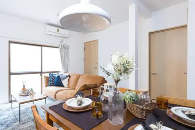 a living room with a table and a couch at Mita Guest House by Tranova in Tokyo