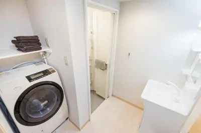 a laundry room with a washing machine in a bathroom at Mita Guest House by Tranova in Tokyo