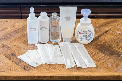 a wooden table with four bottles of soap and other items at Mita Guest House by Tranova in Tokyo