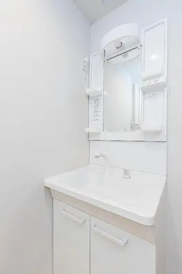 a white bathroom with a sink and a mirror at Mita Guest House by Tranova in Tokyo