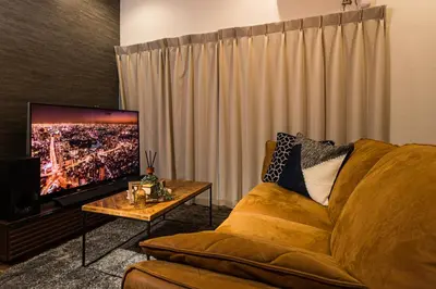 a living room with a couch and a flat screen tv at Mita Guest House by Tranova in Tokyo