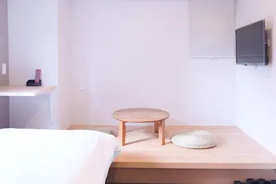 a small stool sitting on a wooden table in a bedroom at The Light Inn Tokyo in Tokyo