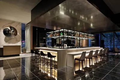 a bar in a room with chairs and bottles at AC Hotel by Marriott Tokyo Ginza in Tokyo