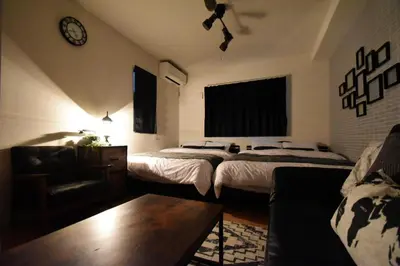 a bedroom with two beds and a couch and a clock at Hikifune Kodate - Vacation STAY 8861 in Tokyo