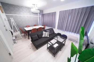 a living room with a black couch and a table at Kitaikebukuro Kodate - Vacation STAY 8854 in Tokyo