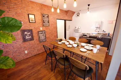 a dining room with a table and a brick wall at Horikiri 3-chome detached house - Vacation STAY 8849 in Tokyo