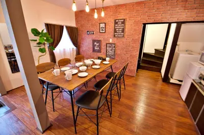 a dining room table with chairs and a brick wall at Horikiri 3-chome detached house - Vacation STAY 8849 in Tokyo