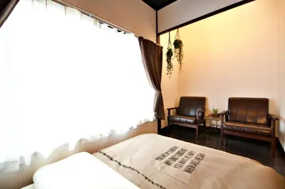 a bedroom with two chairs and a bed and a window at Horikiri 3-chome detached house - Vacation STAY 8849 in Tokyo