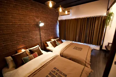 a bedroom with two beds and a brick wall at Horikiri 3-chome detached house - Vacation STAY 8849 in Tokyo