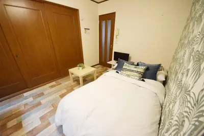 a bedroom with a large white bed and a wooden floor at Ikebukuro Kodate - Vacation STAY 8859 in Tokyo
